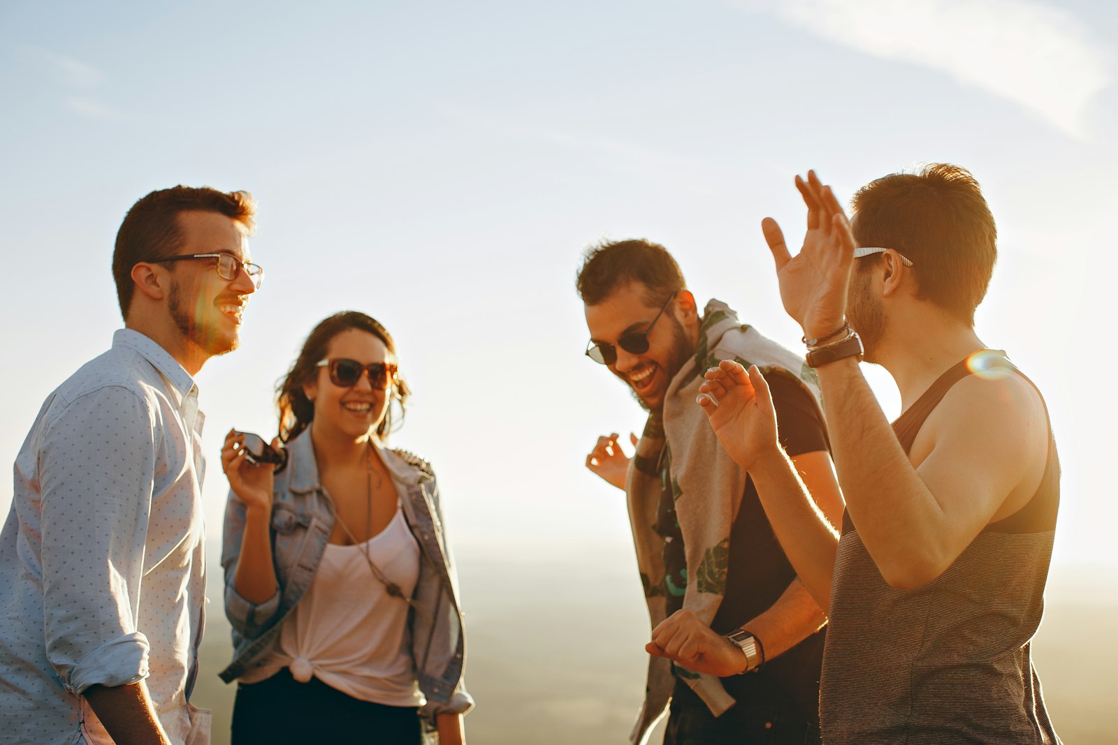 Vier Freunde lachen gemeinsam draußen