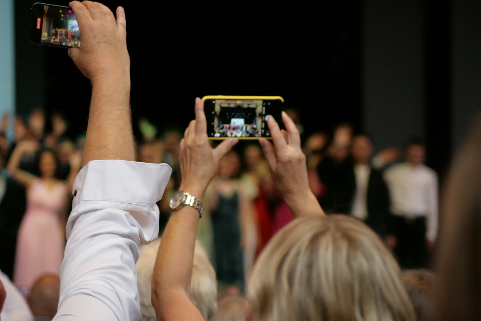 Mehrere Gäste halten ihre Smartphones hoch und fotografieren gleichzeitig