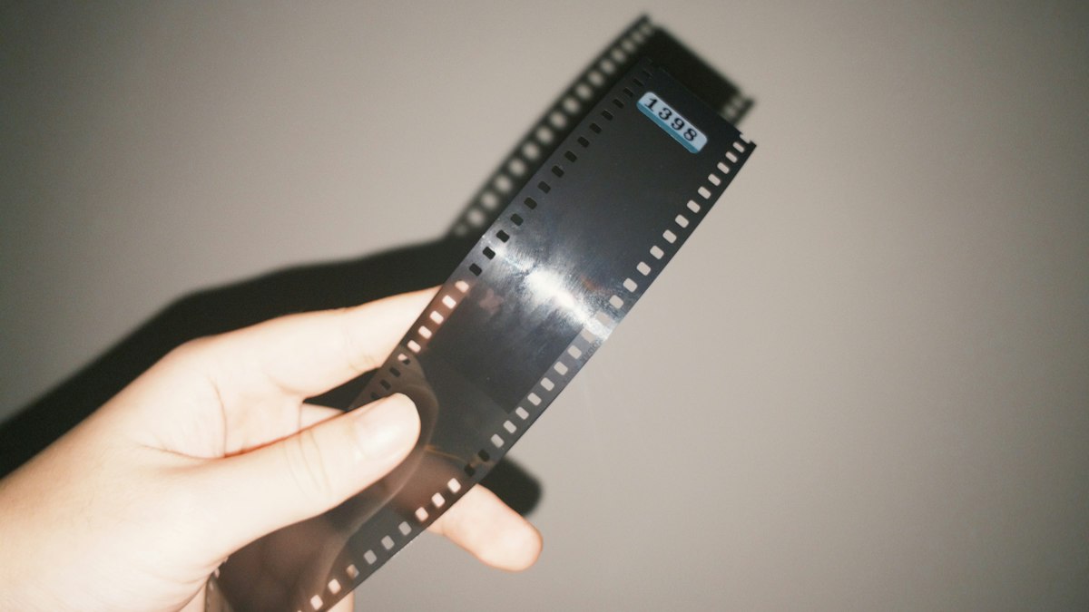 Hand hält einen entwickelten 35-mm-Filmstreifen ins Licht