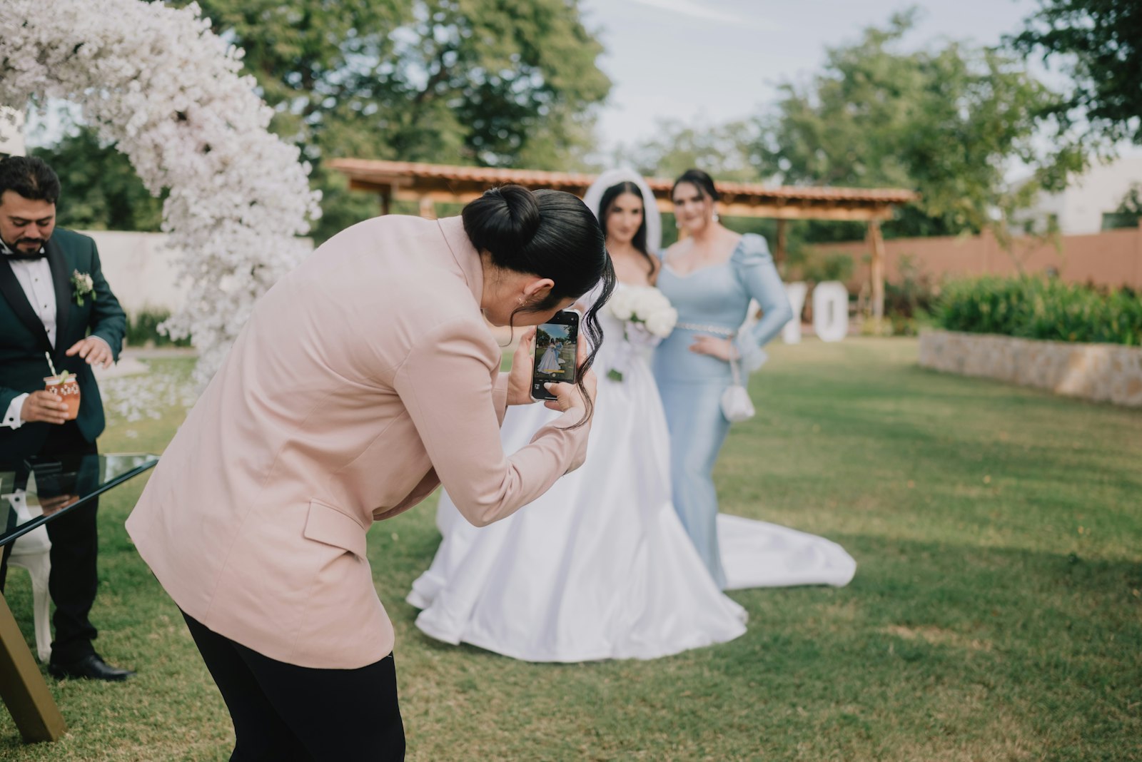 Ein Fotograf fotografiert Braut und Trauzeugin im Freien